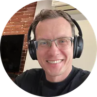 Yuriy Seniuk smiling, wearing glasses and headphones